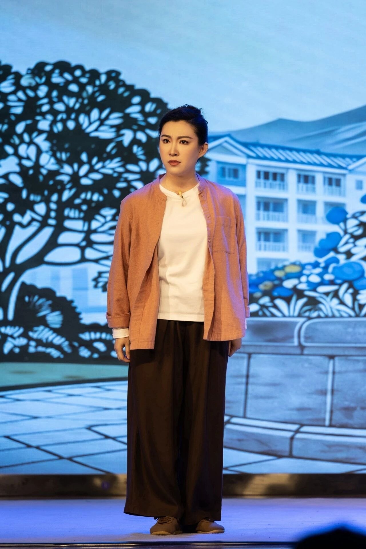 原创京剧《平凡之光》首演剧照:社区工作者形象(现代戏扮相,彩绘社区景片前)