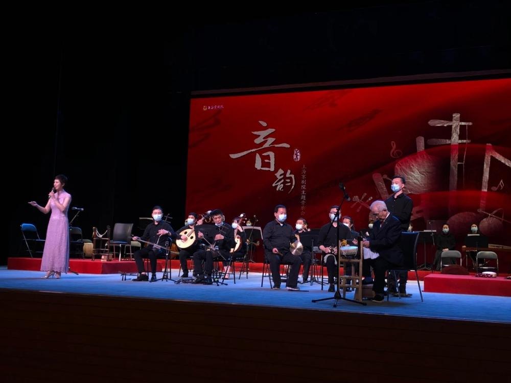 王玉璞(右)在音乐会舞台上司鼓,民族乐队于台上伴奏