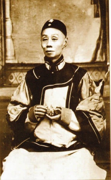 谭鑫培便装照(清末民初照相馆拍摄,戴瓜皮帽、着深色对襟马甲与浅色长衫,坐姿半身像;本人影像)