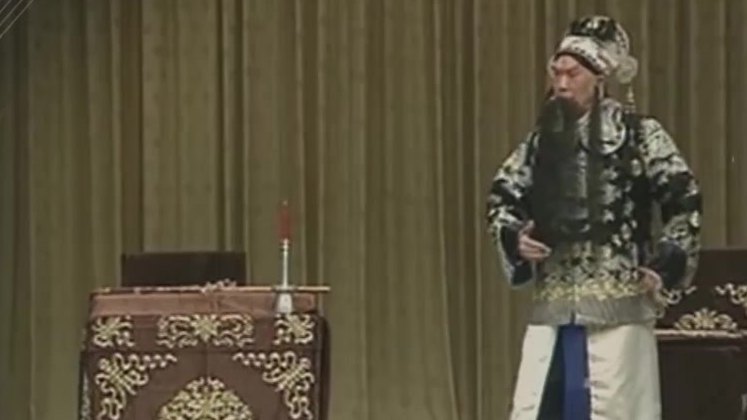 京剧《文昭关》录像截帧:伍子胥做戏身段,侧设桌案(录音杨宝森、配像汪正华)