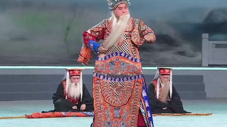 京剧《李陵碑》录像截帧:杨继业唱「七郎儿被潘洪箭射花标」,身后二随从跪地(表演:万琳)