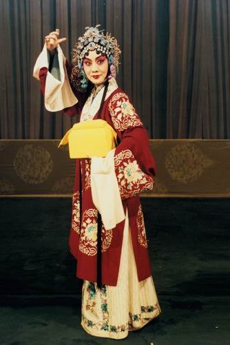 京剧《穆桂英挂帅》剧照:穆桂英红帔白裙、手托黄色砌末(国家京剧院官网剧目页所载)