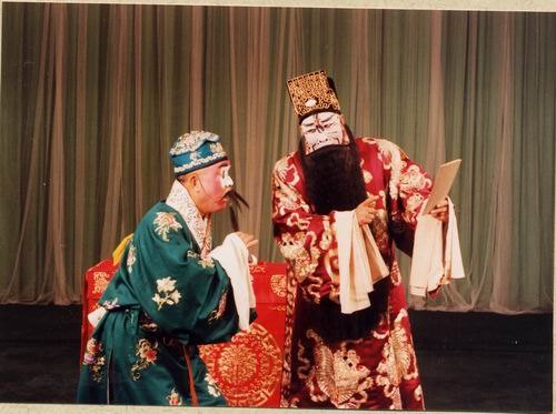 京剧《群英会》剧照:丑角与净角对坐,案上置书册(国家京剧院官网剧目页所载)