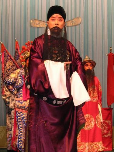 京剧《群英会》剧照:老生、扎靠净角与持书官员同场(国家京剧院官网剧目页所载)