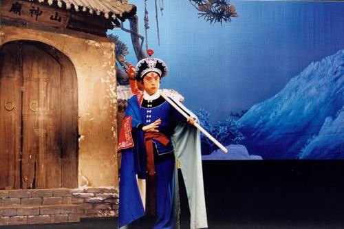 京剧《野猪林》剧照:布景门额作「山神庙」,林冲持枪立于庙前(国家京剧院官网剧目页所载)